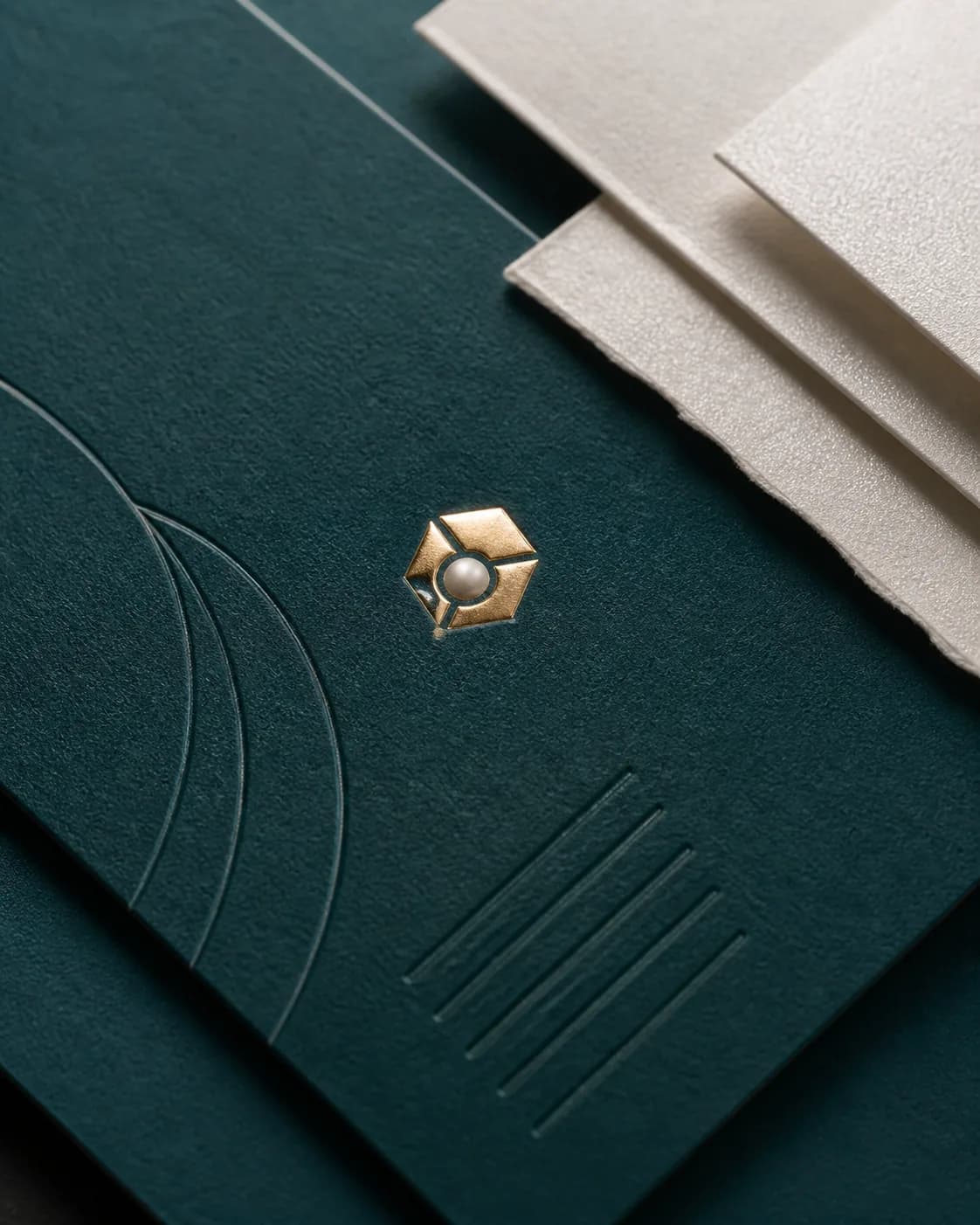 Deep teal paper stock with refined metallic finishing details